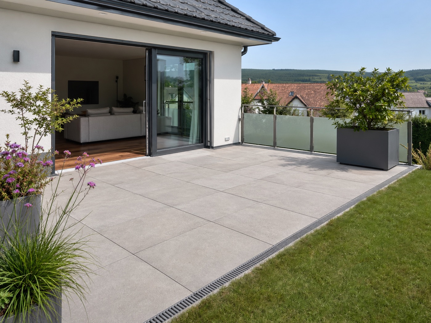 Moderne Terrasse mit großformatigen Außenplatten und Entwässerungsrinne