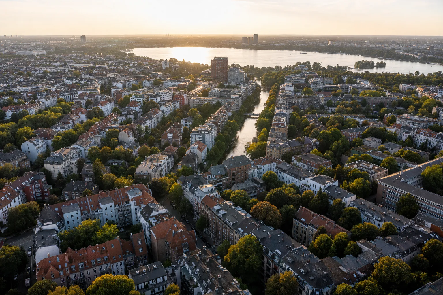 Drohnenblick über die Dächer von Winterhude Richtung Außenalster am Abend