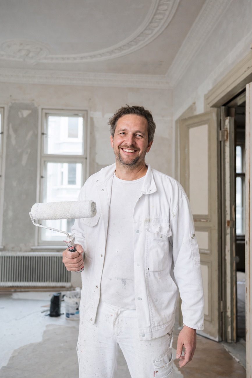 Malermeister Jonas Brandt in einem frisch vorbereiteten Hamburger Altbauzimmer