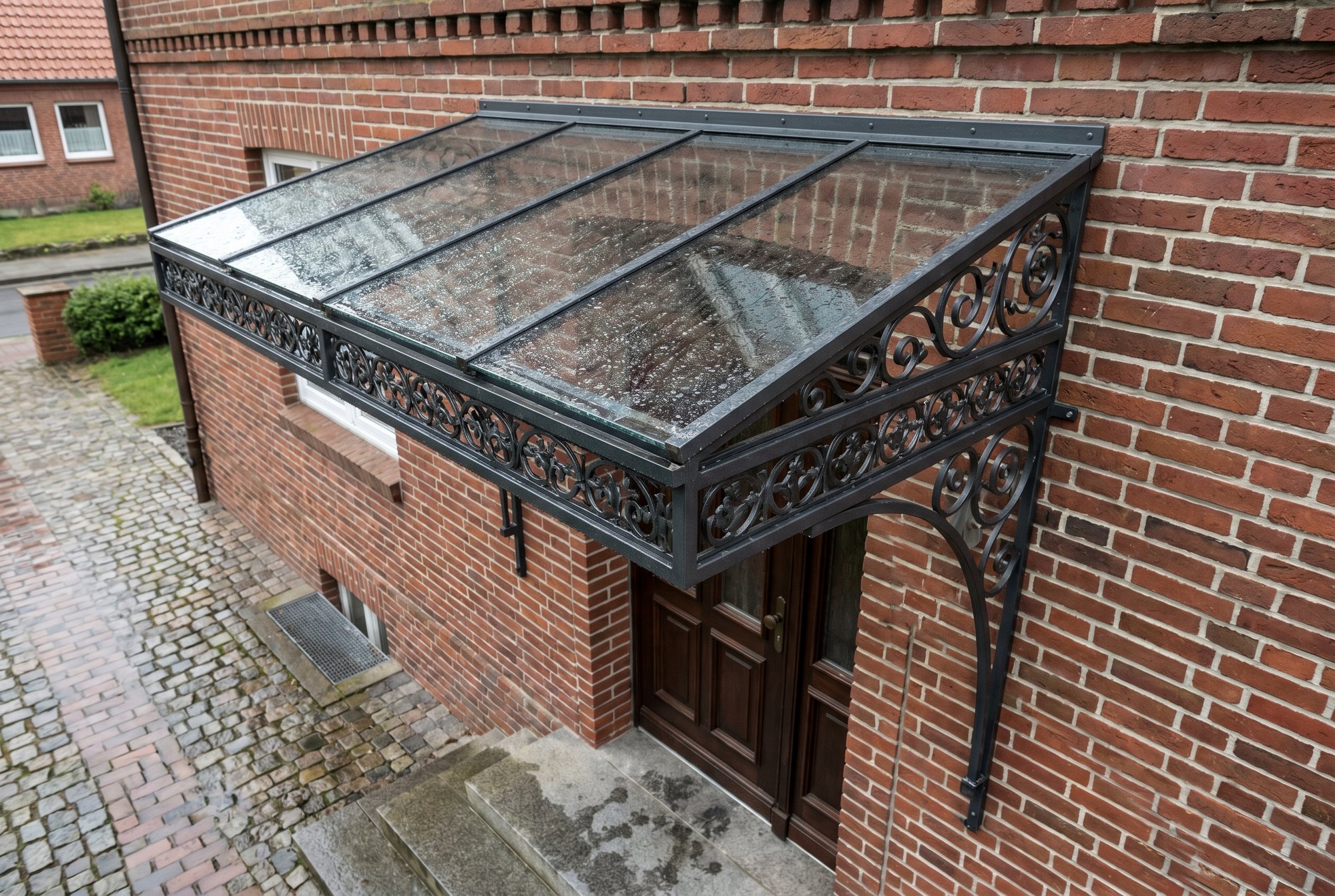 Filigranes Stahl-Vordach mit Glaseindeckung über einer Haustür