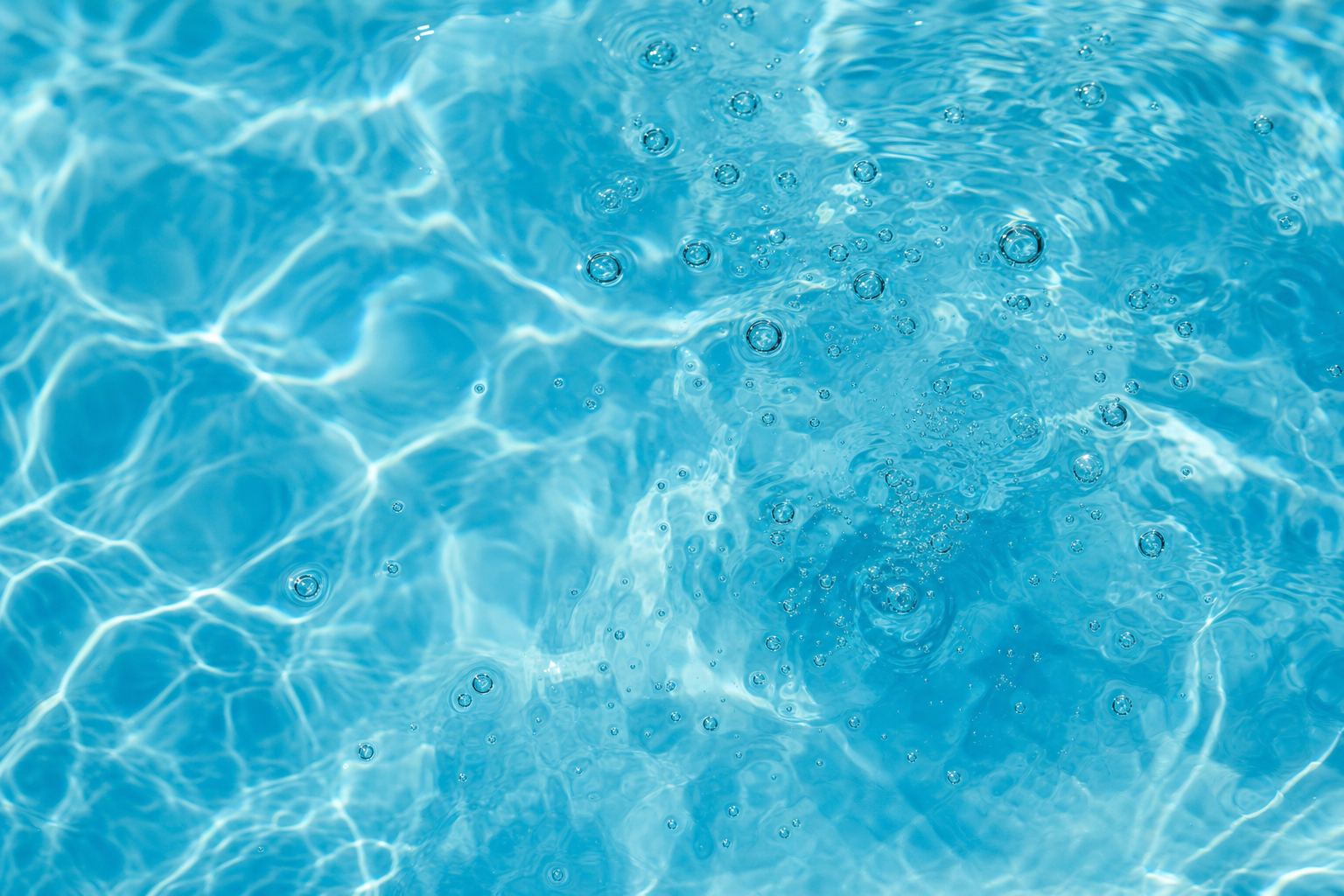 Sanft gekräuselte türkisblaue Wasseroberfläche mit Lichtmustern